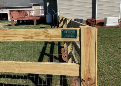 A wooden fence with a sign on it, providing information or instructions.